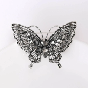 Detailed macro view of vintage silver butterfly brooch with dark grey crystal stones