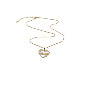 Détail d'un pendentif coeur doré orné d'une inscription LOVE sertie de diamants