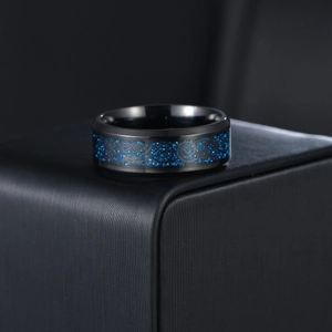 Close-up of black stainless steel ring with intricate blue dragon inlay and polished finish