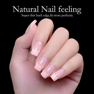 Macro shot of French square press-on nails in nude pink and white with a natural finish
