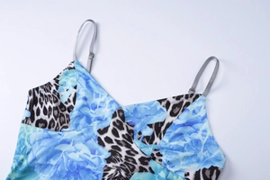 Détail de fines bretelles grises et décolleté en V avec motif floral bleu et léopard
