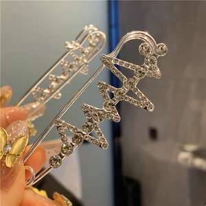 Detailed view of silver zigzag safety pins with crystals for waist adjustment