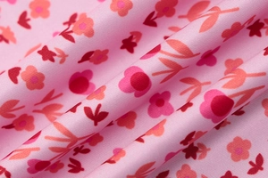Macro shot of smooth floral fabric with pink and red flowers for summer dress
