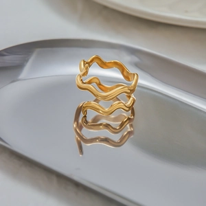 Macro detail of wave-shaped 18K gold stainless steel ring with liquid metal mirror finish
