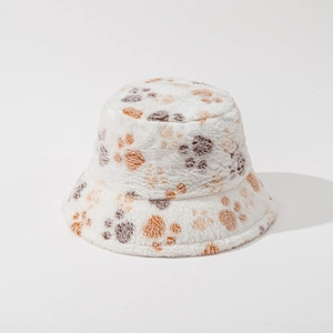 Detailed view of plush white bucket hat with brown paw print pattern and soft texture