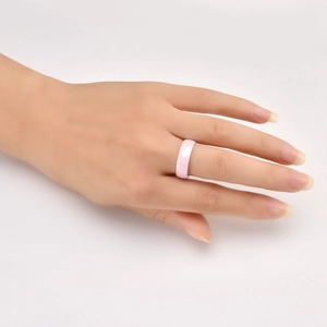 Polished pink ceramic ring for couples with minimalist curved surface on hand