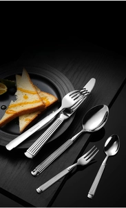 Detailed view of silver stainless steel flatware set with elegant ribbed column handles