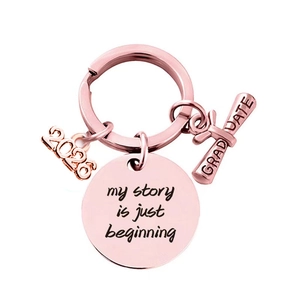 Macro detail of rose gold 2026 graduate keychain with my story is just beginning engraving