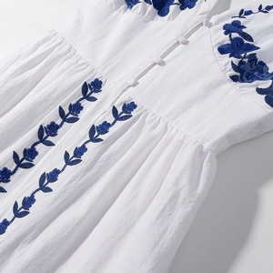 White cotton linen midi dress with blue floral embroidery and waist button detail