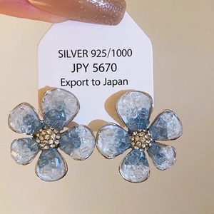 Macro shot of blue flower earrings with 925 silver studs and crystal petals details