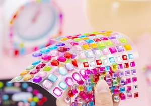 Close-up of colorful acrylic gemstone stickers in various geometric shapes for DIY crafts