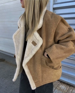 Détail de la veste en daim marron avec doublure et col en peau de mouton blanche douce