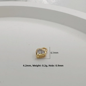Macro shot of S925 sterling silver gold heart charm with clear zircon and hallmark detail