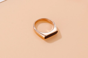 Top view of rose gold stainless steel ring with a rectangular black resin inlay
