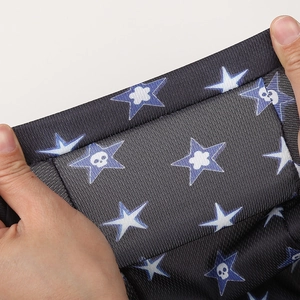 Détail du tissu en maille extensible et respirant avec imprimé de crânes et étoiles