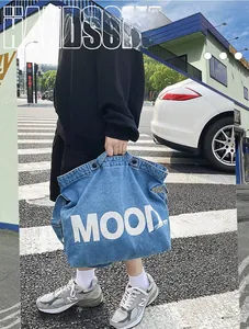 Close-up of blue denim tote bag with white MOOD text lettering and high capacity