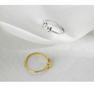 Detailed macro shot of S925 sterling silver bow rings in gold and silver finishes
