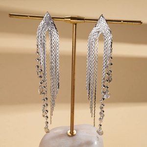 Gros plan de boucles d'oreilles pampilles argentées en maille métallique avec perles