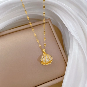 Elegant gold titanium steel shell pendant necklace with zircon on a beige jewelry box