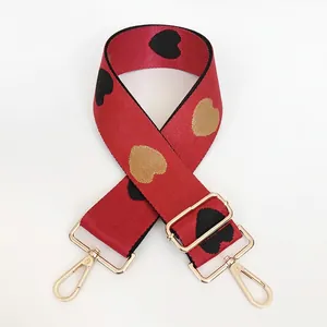 Detail of red jacquard heart strap with gold metal hooks and adjustable buckle
