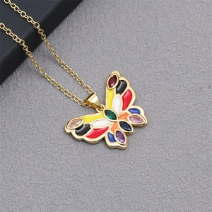 Macro shot of colorful enamel butterfly pendant on gold chain with detailed texture