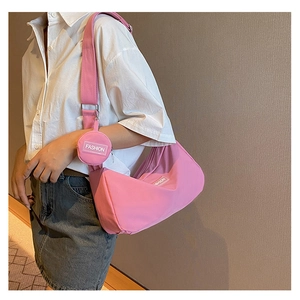 Detailed view of a pink half-moon crossbody bag with a round coin pouch on wide strap