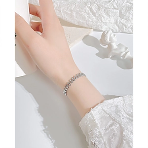 Close-up of elegant silver wheat ear bracelet with leaf links on female wrist