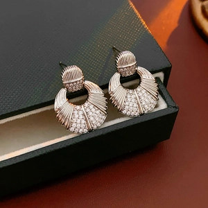 Gros plan de boucles d'oreilles en forme de coquille argentée avec pavé de zircons clairs