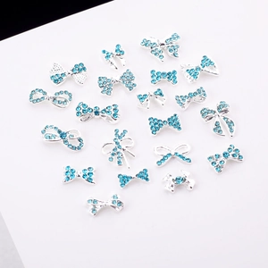 Vue à plat de divers nœuds nail art en métal argenté avec strass bleu clair étincelant