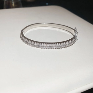Detail of silver clasp and double-row zircon setting on minimalist silver-toned bangle