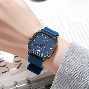 Close-up of square blue dial watch with Roman numerals and leather strap on wrist