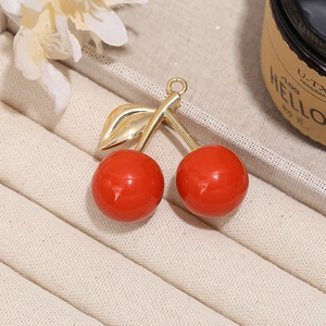 Red cherry pendant with gold leaf details on a white flower decorative background