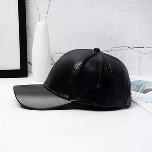Side view detail of a sleek black PU leather baseball cap with a smooth modern finish