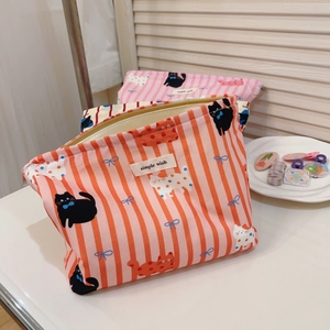 Détail de trousse cosmétique en tissu avec rayures rétro, chat et fermeture éclair