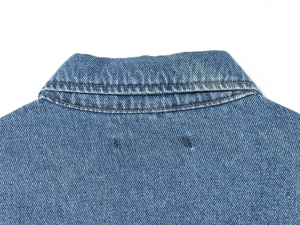 Detailed close-up of the collar and shoulder seams on this blue denim jacket for women