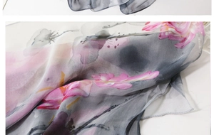 Detailed macro view of soft pink floral silk scarf showing fabric texture and translucency