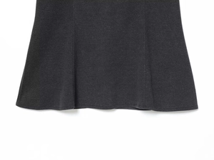 Detail of black knit dress hem showing thick texture and precise stitching craftsmanship