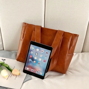 Caramel brown PU leather tote bag with large capacity showing tablet storage space