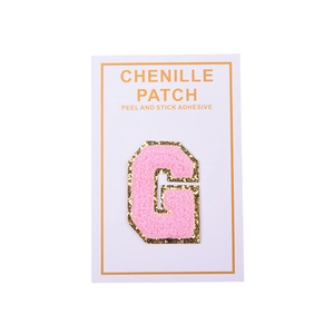 Detail of pink chenille letter G patch with gold glitter border and adhesive backing