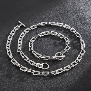 Detail of silver stainless steel chain jewelry set featuring toggle clasp and square links