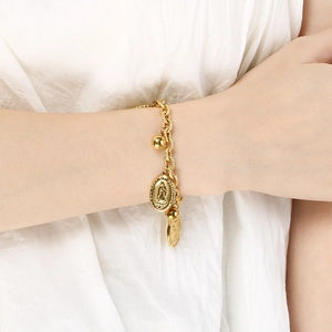Detailed shot of golden chain bracelet with Our Lady of Guadalupe and gold ball charms
