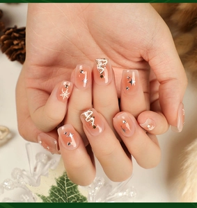 Detail of square festive Christmas press-on nails with white snowflakes and star glitter