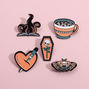 Gothic Halloween enamel pins set featuring skull, moth, and dagger on pink background