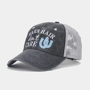 Detail of embroidered BARN HAIR DON'T CARE text on a washed cotton ponytail mesh cap