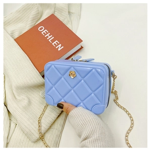 Close-up of blue PVC quilted jelly bag with gold flower buckle and chain strap