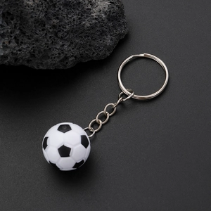 Detail shot of a black and white 3D soccer ball keychain with silver metal ring and chain