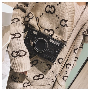 Detail shot of a black sequin camera-shaped crossbody bag with a metal chain strap