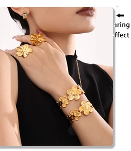 Detailed view of flower jewelry set with gold plated ring, bracelet, and necklace on model