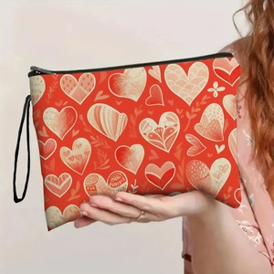 Fashionable red heart print makeup bag with black zipper and wristlet held by model