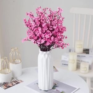 Pink artificial gypsophila bouquet in a white textured ceramic vase for home decor
